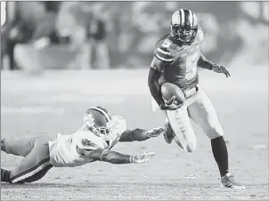  ?? Wilfredo Lee/Associated Press ?? Ohio State quarterbac­k Braxton Miller runs past Clemson safety Robert Smith on his way to a touchdown in the first half of the Orange Bowl Friday night in Miami Gardens, Fla.