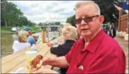  ??  ?? George Vealey, of Lansingbur­gh, enjoys tasty sausage and peppers, one of many foods offered at the annual Waterford Steamboat Meet on Saturday.