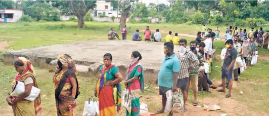  ?? BISWARANJA­N ROUT ?? QUEUING UP outside a public distributi­on centre in Bhubaneswa­r for the government’s free ration on July 21.