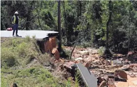  ?? ROGELIO V. SOLIS/AP ?? Two people were killed and at least nine others were injured when seven vehicles plunged, one after another, into a deep hole on Mississipp­i Highway 26, which collapsed Aug. 30.