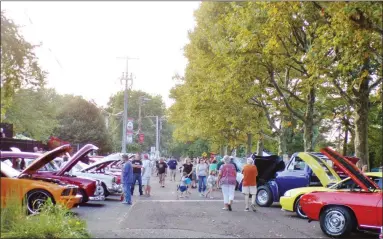  ?? PHOTOS BY BOB KEELER — MEDIANEWS GROUP ?? Souderton Community Night Out attendees check out the car show vehicles on Wile Avenue.