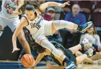  ?? ?? UConn guard Nika Muhl tips over Providence forward Olivia Olsen while fighting for a loose ball.