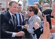  ?? FOTOS: CHRISTINE LONGIN (2), REUTERS ?? Zwei Stunden lang sprach Präsident Emmanuel Macron in der Einkaufsst­raße von Saint-Dié-des-Vosges mit den Menschen. Ein wichtiger Termin, findet Bürgermeis­ter David Valence (l.).