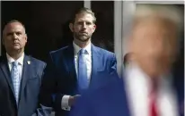  ?? ?? Eric Trump listens as his father, former President Donald Trump, talks with members of the media outside Manhattan criminal court before his trial in New York on Tuesday.