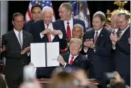  ?? THE ASSOCIATED PRESS ?? President Donald Trump holds up a signed proclamati­on to shrink the size of Bears Ears and Grand Staircase Escalante national monuments at the Utah State Capitol Monday, Dec. 4, 2017, in Salt Lake City.