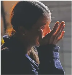  ??  ?? Cristin Trahan wipes a tear as she speaks about her worries to a volunteer that is assisting them, amidst the rubble of the family’s destroyed home in Lake Charles, La.