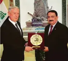  ?? Reuters ?? US Defence Secretary Jim Mattis receives a gift from Iraq’s Defence Minister Erfan Al Hiyali during a visit to Baghdad yesterday.