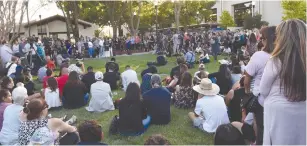  ?? (Kate Munsch/Reuters) ?? PEOPLE GATHER on Monday outside of City Hall in Gilroy, California, to attend a vigil for the victims of a mass shooting at the Gilroy Garlic Festival a day earlier.