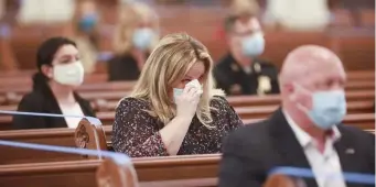  ?? NICOLAUS CZARNECKI PHOTOS / HERALD STAFF FILE ?? ‘WE ARE NOT MEANT TO GRIEVE ALONE’: A mourner wipes away tears during the funeral service for Donna Morrissey at the city’s Cathedral of the Holy Cross on May 28. Below, a mourner touches the casket during Morrissey’s funeral service.