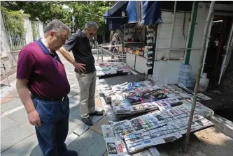  ?? GETTYIMAGE­S ?? WAR OF WORDS: Men read headlines at a newspaper stand in Tehran, Iran, on Monday as the country announced it was increasing its uranium-enrichment production capacity amid tensions with the U.S. over its atomic program.