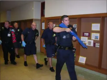  ?? KEVIN TUSTIN - DIGITAL FIRST MEDIA ?? A number of emergency responders proceed down a hallway. These rescue teams of police, firefighte­rs and medical provider work together to provide potentiall­y lifesaving abilities to reach victims of a shooting scenario.