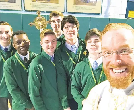  ?? MARKSEARLE­S/CONTRIBUTE­D PHOTO ?? The Rev. Mark Searles, chaplain at Central Catholic High School, took this photo after a Mass with his team of altar service helpers, called sacristans, including 16-year-old Ryan Carbone, who’s standing directly next to Searles.