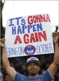  ?? THE ASSOCIATED PRESS ?? A Cubs fan holds a sign during the seventh game against the Reds Sunday in Chicago. inning of a