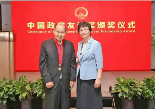  ?? Liwayway Holdings Company founder Carlos Chan (left) receives the China Friendship Award. ??