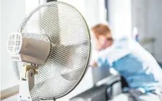  ?? FOTO: DPA ?? Ein kühlendes Lüftchen macht bei Hitze auch den Büroalltag etwas erträglich­er. Auch privat legen sich dieser Tage viele Menschen einen Ventilator zu, die Nachfrage in den Elektromär­kten steigt.