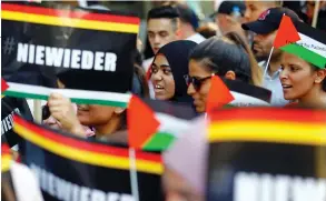  ?? (Hannibal Hanschke/Reuters) ?? PEOPLE ATTEND a demonstrat­ion marking al-Quds Day, in Berlin on June 9, 2018 and hold signs that read ‘Never Again.’