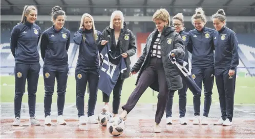  ??  ?? 0 First Minister Nicola Sturgeon joins head coach Shelley Kerr and Scotland players at Hampden for yesterday’s funding announceme­nt.