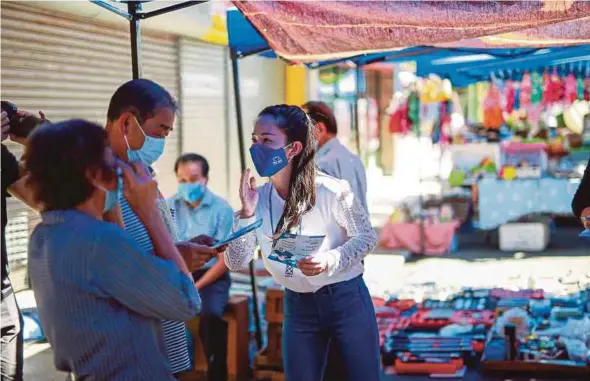  ?? ASWADI ALIAS PIC BY ?? Barisan Nasional’s Likas candidate Dr Chang Kee Ying (right) handing out brochures on the campaign trail in Kota Kinabalu yesterday.