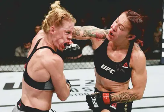  ??  ?? Brasileira Cris Cyborg desfere um soco de direita no rosto da americana Holly Holm na luta em que se manteve como dona do cinturão peso pena