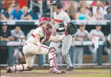  ?? NWA Democrat-Gazette/BEN GOFF • @NWABENGOFF ?? Adley Rutschman, Oregon State catcher, runs in to score ahead of a throw to Arkansas catcher Grant Koch on a sacrifice fly in the fifth inning.