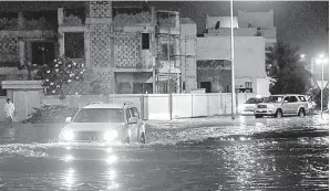  ?? — Gambar AFP ?? BANJIR KILAT: Kenderaan dilihat bergerak di jalan yang dilanda banjir di bandar Isa di selatan Bahrain semasa hujan lebat kelmarin.