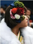  ??  ?? Draped in traditiona­l kimono, a 20-year-old woman gather for her "Coming-of-Age Day" ceremony.