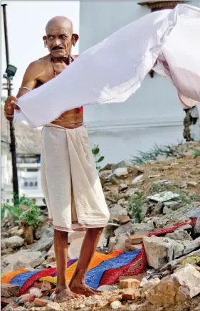  ?? REUTERS NEW DELHI ?? A man dries his clothes after taking a bath at a lake in Pushkar, in the desert state of Rajasthan on Thursday.