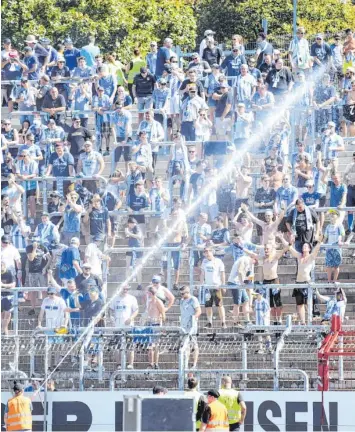  ?? Foto: Uli Deck, dpa ?? Im Karlsruher Wildpark herrschten Temperatur­en deutlich über der 30-Grad-Marke. Da waren auch die Fans des TSV 1860 nicht unglücklic­h darüber, dass sie von den KSC-Ordnern nass gemacht wurden.