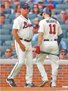  ?? THE ASSOCIATED PRESS ?? Atlanta Braves manager Brian Snitker, left, comes out of the dugout to pull Ender Inciarte away from arguing a called third strike in the sixth inning of Sunday’s game against the Colorado Rockies. The Rockies completed a sweep of the four-game series.