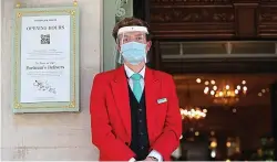  ?? PA ?? Red alert:
A doorman wears a mask and visor at Fortnum & Mason in London