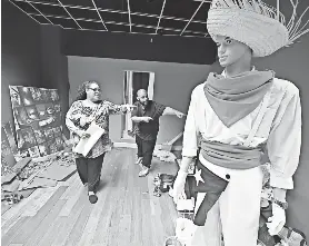  ?? ?? Artist Elis Ortiz and his mother Maria Calderon pick out fabrics for his window at the Denholm building that is dedicated to Puerto Rican culture.