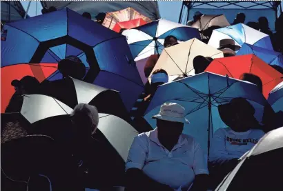  ?? COURTNEY PEDROZA/THE REPUBLIC ?? Umbrellas provide some relief from the blazing sun for spectators at the state high-school track championsh­ips in Mesa this past spring.