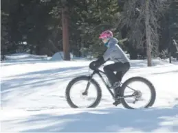  ??  ?? Sydney Fox of Breck Bike Guides cruises up a trail during a Fat Bike Tour near Breckenrid­ge in January 2015. Andy Cross, Denver Post file