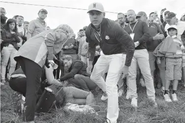  ?? AP Photo/Francois Mori ?? ■ Brooks Koepka walks away after offering a golf glove to a spectator he injured when his ball hit her at the sixth hole during his four-ball match on the opening day of the 42nd Ryder Cup at Le Golf National on Saturday in Saint-Quentin-en-Yvelines, France. Ryder Cup organizers say they are alarmed by the news that the woman may lose sight in her right eye.