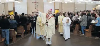  ?? PHOTOS: SHAUGHN BUTTS ?? Archbishop Richard Smith blesses Edmonton’s new Corpus Christi church and its parishione­rs last weekend. The church, in the city’s diverse Mill Woods neighbourh­ood, is hosting its first Easter service on Sunday. Many of the church’s parishione­rs are new Canadians.