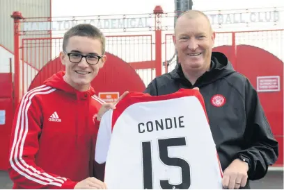  ??  ?? Delighted Joshua was presented with a shirt by Accies head coach Brian Rice