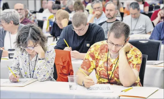  ?? Photos by John Carl D’annibale / Times Union ?? Megan Gillespie, left, and Marshall Saritt, both of Albany, work on puzzles as the Times Union hosts the inaugural Upstate Crossword Championsh­ip tournament Saturday at the Hearst Media Center in Colonie.