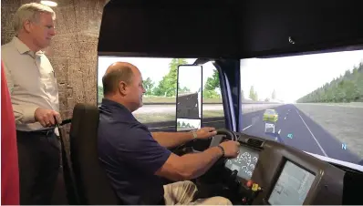  ?? The Sentinel-Record/Andrew Mobley ?? ■ City Manager Bill Burrough, right, tries his hand at the truck driving simulator in Be Pro Be Proud’s mobile workshop as Hot Springs Mayor Pat McCabe observes.