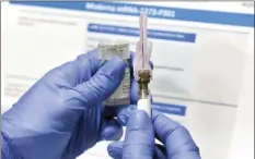  ?? AP file photo ?? A nurse prepares a shot as a study of a COVID-19 vaccine, developed by the National Institutes of Health and Moderna Inc., on July 27.