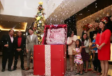  ??  ?? GM Ken Kapulong with his ManCom, Ms. Marie Bumanlag and Smile Train kids and DOT RD Tanya Rabat-Tan open the Christmas gift box to light up the hotel