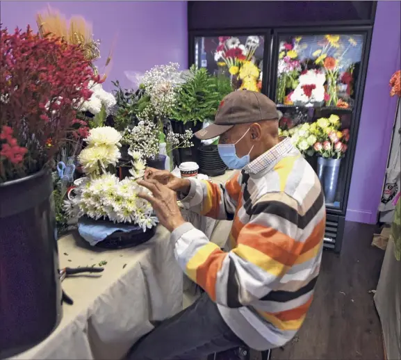  ?? Photos by Will Waldron / Times Union ?? Designer Phil Copeland creates an arrangemen­t at Marie Campbell's flower shop, Blooms By Marie, on Madison Avenue in Albany.