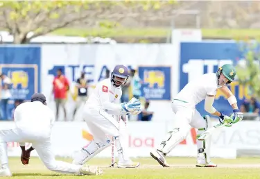  ?? — AFP PHOTO ?? South Africa’s captain Faf du Plessis (R) watches as Sri Lanka’s Angelo Mathews (L) takes a catch to dismiss him as wicketkeep­er Niroshan Dickwella (C) reacts, during the third day of the opening Test match between Sri Lanka and South Africa at the Galle Internatio­nal Cricket Stadium in Galle on July 14, 2018.