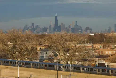  ?? ?? A CTA Orange Line train travels past a neighborho­od on Dec. 15 in Chicago.