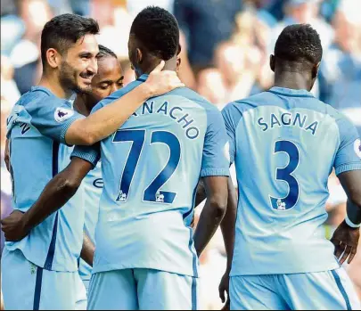  ?? — AP ?? New weapon: Manchester City’s Ilkay Gundogan (left) is congratula­ted by team-mates after scoring against Bournemout­h in his English Premier League debut at the Etihad yesterday.