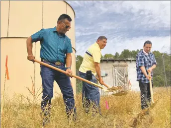  ?? GEOFFREY PLANT/Taos News ?? From left, Tom Sanchez, president of the Lower Hondo Mutual Domestic Water Consumers Associatio­n, Steven Martinez, secretary, and Herb Medina, treasurer, break ground on a water infrastruc­ture project in Arroyo Hondo on Tuesday (Sept. 20). The associatio­n's water tank and well house are seen in the background.