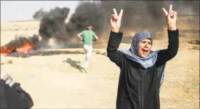  ?? Hosam Salem / The New York Times ?? Protesters near the Gaza border with Israel on Tuesday. Hamas dialed back the protests on Tuesday, and the mosque loudspeake­rs that had urged Gazans to protest on Monday were largely silent.