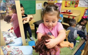  ?? NWA Democrat-Gazette/DAVID GOTTSCHALK ?? Abbygail Gonzalez, 3, plays with her doll Monday in the Arkansas Better Chance toddler room at the Northwest Arkansas Sunshine School and Developmen­t Center in Little Flock. The school has been serving children with developmen­tal delays or disabiliti­es...