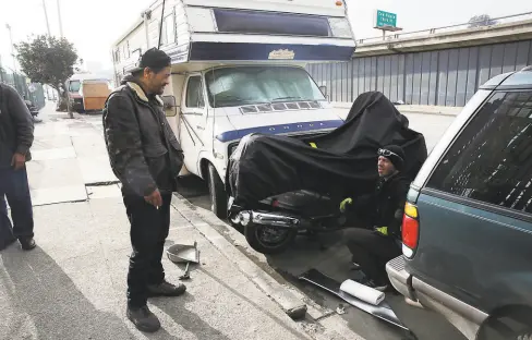  ?? Lea Suzuki / The Chronicle 2019 ?? Roy Santos (left) talks with Mohamed Harrouchi along Bayshore Boulevard, where they have lived in vehicles. Lawyers for nonprofit advocacy group, the Coalition on Homelessne­ss, have sued to stop the socalled poverty tows that result from five unpaid parking tickets.