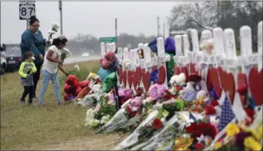  ?? ERIC GAY — THE ASSOCIATED PRESS ?? Christina Osborn and her children Alexander Osborn and Bella Araiza visit a makeshift memorial for the victims of the shooting at Sutherland Springs Baptist Church, Sunday in Sutherland Springs, Texas. A man opened fire inside the church in the small...