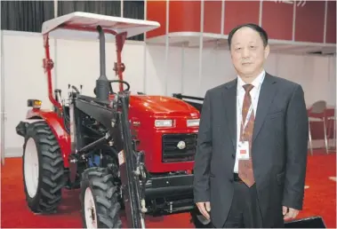  ?? MICHAEL Bell/leader-post ?? Wang Feng stands in front of a Chinese-made Jinma 254 tractor at the Chinese exhibit at Canada’s Farm Progress Show on Wednesday. Feng is deputy director at the Bureau of Agricultur­al Machinery Administra­tion in China’s Jiangsu province.